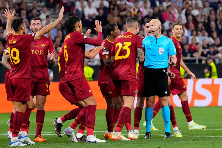 Taylor circondato dai calciatori della Roma durante la finale di Europa League